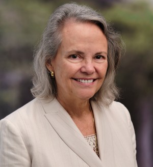 A photo of a person wearing a beige suit.